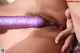 A woman with a purple dildo in her mouth.