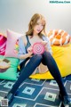 A woman sitting on a bean bag chair holding a lollipop.