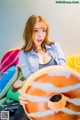 A woman sitting on top of a bed holding a donut.