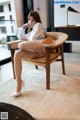 A woman sitting on a chair in a room.