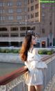 A woman standing on a bridge next to a river.