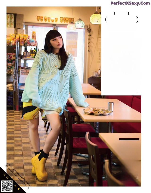 A woman standing in front of a table in a restaurant.