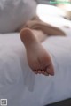 A person laying on a bed with their feet up.