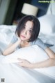 A woman laying on a bed with a pillow.