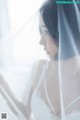 A woman in a wedding dress looking out a window.