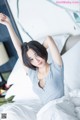 A woman laying on top of a bed with her arms outstretched.