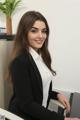 A woman in a business suit sitting at a desk.