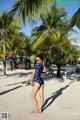 A woman in a polka dot swimsuit standing on a beach.