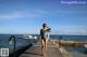 A woman in a bathing suit standing on a dock.