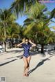 A woman in a polka dot swimsuit standing on a beach.