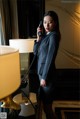 A woman in a business suit talking on a phone.