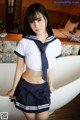 A woman in a sailor outfit posing in a bathtub.