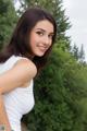 A woman in a white tank top posing for a picture.