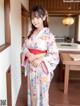 A woman in a kimono standing in a kitchen.