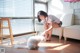 A woman petting a white cat on the floor.