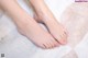 A woman's bare feet on a white rug.