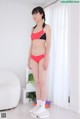 A woman in a red and black bikini standing on a scale.