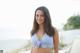 A woman in a blue and white bikini posing for a picture.