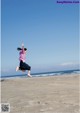 A woman jumping in the air on a beach.