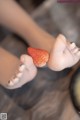 A close up of a person holding a strawberry in their hand.