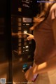 A woman is using a smart phone in an elevator.